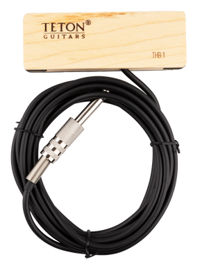 The image shows a TETON Guitars THB-1 soundhole pickup for acoustic guitars. It features a wooden mounting block with branding, a black cable, and a 1/4" instrument jack. Designed to capture string vibrations and amplify the acoustic sound, its wooden housing blends with the guitar’s natural wood, making it a practical accessory for amplified acoustic performances.