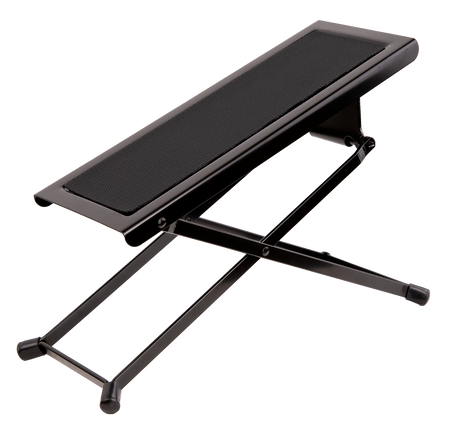 The image shows a guitar footstool with a black metal X-shaped folding frame, a padded cushioned top, adjustable height, and rubber feet for stability. It’s designed for classical and acoustic guitarists to elevate the left foot, promoting proper posture and better control. Portable and foldable, it’s a common accessory in music schools, concert halls, and practice rooms.