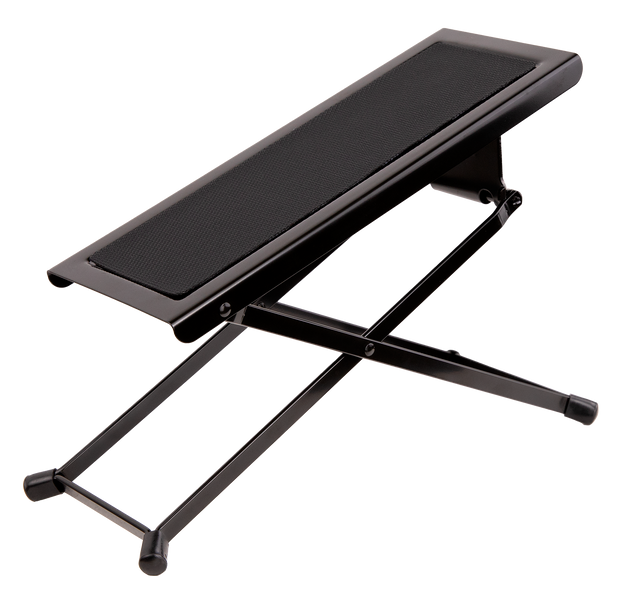 The image shows a guitar footstool with a black metal X-shaped folding frame, a padded cushioned top, adjustable height, and rubber feet for stability. It’s designed for classical and acoustic guitarists to elevate the left foot, promoting proper posture and better control. Portable and foldable, it’s a common accessory in music schools, concert halls, and practice rooms.