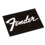 The image shows a black rectangular magnet featuring the iconic white Fender script logo. Fender is a renowned guitar maker famous for models like the Stratocaster and Telecaster. This branded magnet is a simple, classic accessory that fans and guitar enthusiasts might use to show their loyalty on metal surfaces. The clean black and white design reflects Fender’s timeless aesthetic.