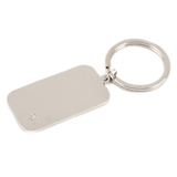 The image shows a plain, silver-colored metallic keychain with a rectangular tag attached to a key ring. There are no clear details indicating a connection to the musical instrument industry. If related, it might be a promotional item or branded accessory from a music store or instrument maker, but no specific logos or text are visible. Additional context is needed to confirm its relevance to musical instruments.