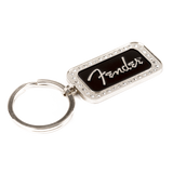 The image shows a Fender keychain featuring a rectangular metal charm with a black center displaying the white Fender logo in signature script. The charm has a decorative beaded border and is attached to a standard split-ring. This music-themed accessory is popular among musicians and fans as a collectible or gift, representing the iconic brand known for electric guitars and amplifiers.
