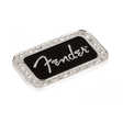 The image shows a Fender logo magnet, a decorative metal emblem featuring the iconic silver "Fender" script on a black background. It is bordered by small rhinestones.