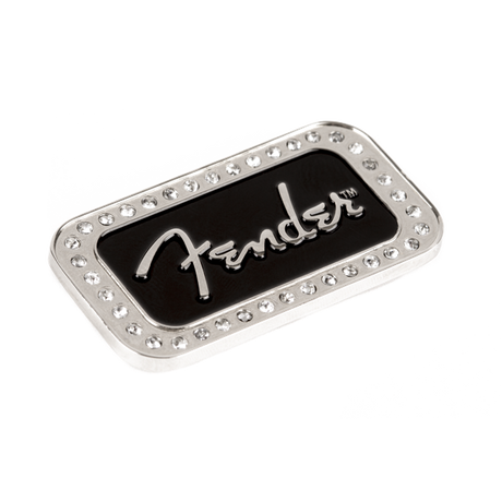 The image shows a Fender logo badge, a decorative metal emblem featuring the iconic silver "Fender" script on a black background. It is bordered by small metallic studs or rivets. Typically used on guitar amplifiers, cases, or Fender gear, this high-quality badge highlights brand loyalty and adds a stylish, detailed finishing touch to musical equipment.