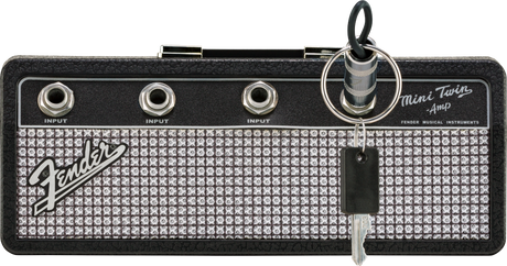 The image shows a compact Fender Mini Twin Amp keychain styled like a miniature guitar amplifier head. It features the Fender logo, “Mini Twin Amp” text, three 1/4" input jacks labeled "INPUT," and classic Fender design with silver sparkle grille and black tolex. This small, portable item resembles Fender’s Twin Reverb amps and is often used as a collectible, practice tool, or novelty accessory.