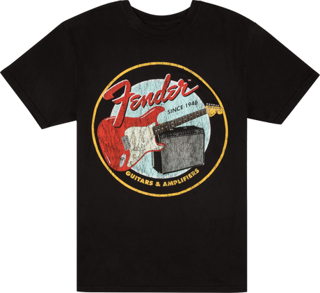 The image shows a black t-shirt with a vintage-style circular Fender logo. It features "Fender" in red script, "Since 1946," a red Stratocaster-style guitar, and a guitar amplifier. The bottom of the circle reads "GUITARS & AMPLIFIERS." This design highlights Fender's legacy as a leading maker of electric guitars and amplifiers.