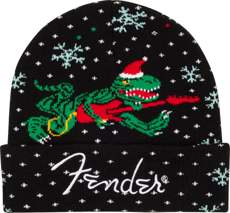 The image shows a black Fender winter beanie featuring the white "Fender" logo at the bottom. The hat displays a festive design with a green alligator wearing a red Santa hat and scarf, surrounded by white snowflakes. This seasonal accessory blends Fender's musical branding with holiday themes, appealing to fans who want to show their support while staying warm during winter.