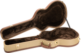 The image shows an open hard shell guitar case with a tan tweed exterior and brown leather trim. It features gold metal latches, a brown leather handle, and a guitar-shaped interior lined with dark plush velvet to protect the instrument. The vintage-style case offers sturdy protection, ideal for safely transporting acoustic or electric guitars, and complements classic or high-end instruments.