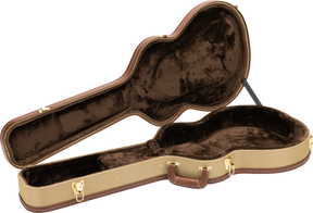 The image shows an open hardshell acoustic guitar case with a tan textured exterior and brown leather-like trim. Its interior has dark brown plush lining and a molded compartment shaped to securely hold the guitar. Gold-toned metal latches, hinges, and an exterior handle are visible. This professional-grade case offers sturdy protection for safe transport and storage of acoustic guitars.