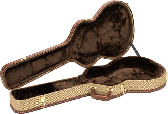 The image shows an open hardshell acoustic guitar case with a tan textured exterior and brown leather-like trim. Its interior has dark brown plush lining and a molded compartment shaped to securely hold the guitar. Gold-toned metal latches, hinges, and an exterior handle are visible. This professional-grade case offers sturdy protection for safe transport and storage of acoustic guitars.