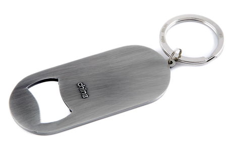 The image shows a sleek, brushed metal Gliga-branded bottle opener keychain with an oval shape and attached keyring. Gliga is a renowned maker of string instruments like violins and cellos. This practical promotional item combines utility with brand visibility, likely given as a gift or sold alongside their instruments to engage musicians and music enthusiasts.