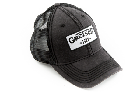 The image shows a dark gray or black distressed trucker hat with mesh backing, featuring a white patch on the front displaying the "Gretsch" logo and "EST 1883." Gretsch is a renowned musical instrument manufacturer known for guitars and drums. This official branded cap is likely promotional merchandise from the company or music stores to promote the Gretsch brand.