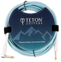 The image shows a Teton Guitars Premium Woven Instrument Cable with a light blue/turquoise woven jacket for durability and style. It has one straight and one right-angle 1/4" (6.35mm) gold-plated plug. The cable is coiled and secured with velcro, displayed in branded packaging featuring a mountain-themed design. This cable is ideal for connecting guitars, basses, and other instruments to audio gear, offering enhanced protection and signal quality.
