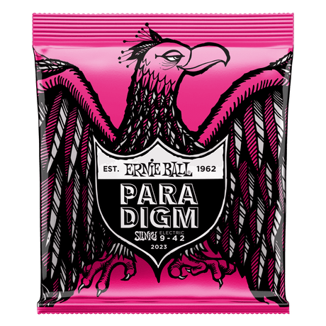 A package of Ernie Ball Paradigm guitar strings with eagle artwork on a pink background