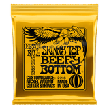 Ernie Ball Skinny Top Beefy Bottom guitar strings gold packaging on a white background