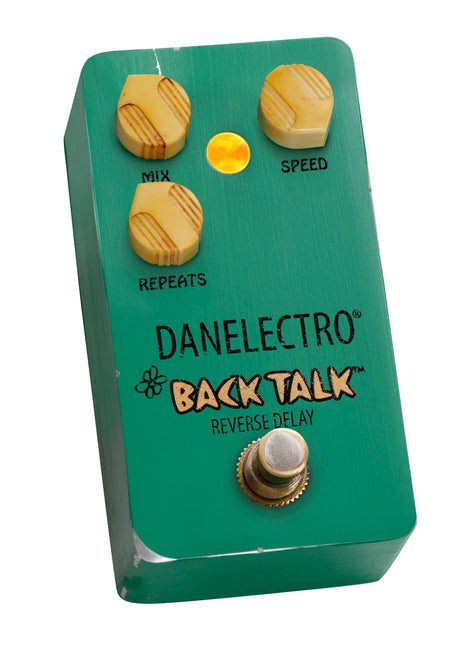 The image shows a Danelectro "Back Talk" reverse delay guitar effects pedal. It has a compact turquoise metal housing with three cream-topped knobs labeled "MIX," "SPEED," and "REPEATS," a yellow LED indicator, a metal footswitch, and branding with "BACK TALK" and "REVERSE DELAY" text. This pedal creates a reverse delay effect, adding atmospheric echoes to a guitar signal chain.