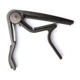 Metallic guitar capo on a white background
