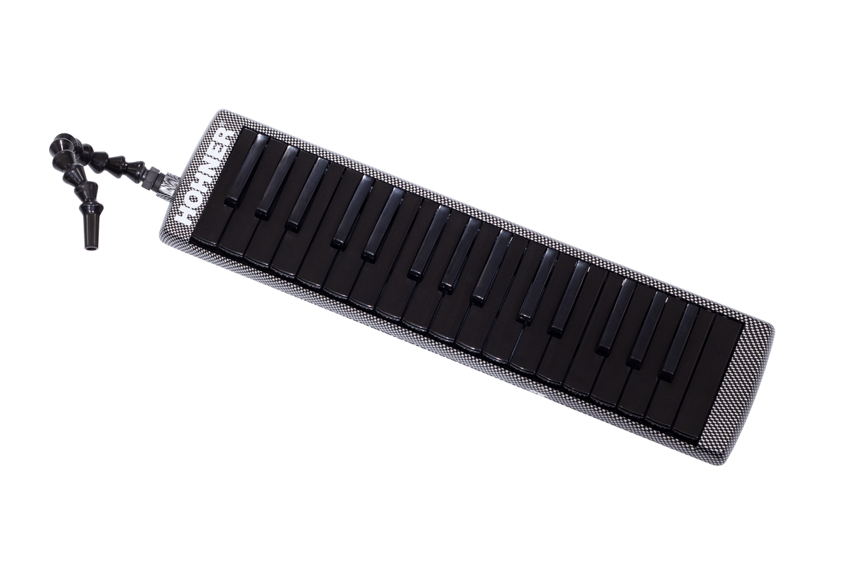 The image shows a melodica, a hybrid wind and keyboard instrument with a piano-style keyboard featuring black and white keys. It has a black and white checkered or carbon fiber-like case, a flexible black mouthpiece tube for comfortable playing, and "HOHNER" branding, indicating the German manufacturer. The melodica is played by blowing air through the mouthpiece while pressing keys, popular in music education and various genres.