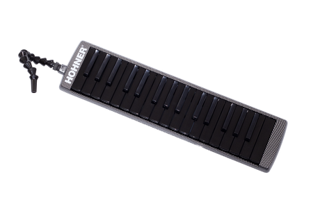 The image shows a melodica, a hybrid wind and keyboard instrument with a piano-style keyboard featuring black and white keys. It has a black and white checkered or carbon fiber-like case, a flexible black mouthpiece tube for comfortable playing, and "HOHNER" branding, indicating the German manufacturer. The melodica is played by blowing air through the mouthpiece while pressing keys, popular in music education and various genres.