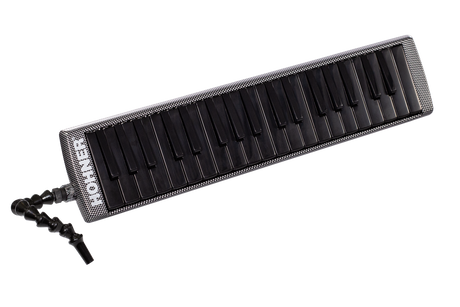 The image shows a melodica, a wind instrument with a piano-style keyboard of about 37 keys. It has a black flexible tube mouthpiece, a sleek black and silver/carbon fiber-look casing, and visible "ROCK" branding. Played by blowing air and pressing keys, it uses free reeds to produce sound. This modern model appears designed for professional use, popular in genres like reggae and educational music.