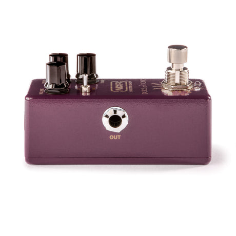 The image shows a compact, purple/burgundy guitar effects stompbox pedal with two dark control knobs on the left, one silver knob on the right, a 1/4" output jack labeled "OUT," a silver footswitch, and branding on top. This pedal is used by guitarists to modify their sound, connecting between guitar and amp to create effects like distortion, delay, or reverb. It’s designed for live and studio use, powered by a 9V battery or adapter.