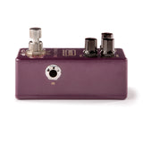 The image shows a compact, purple/burgundy guitar effects pedal with a metal enclosure. It features one silver footswitch on the left, two black control knobs on the top right, and an input jack labeled "IN" on the front. The pedal has standard 1/4" audio jacks for guitar and amp connections, with some text on the top surface. This stompbox-style pedal is used by musicians to alter guitar sound effects during performances.