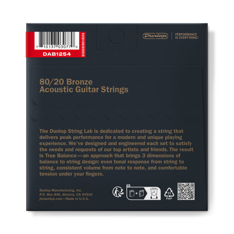The image shows the back packaging of Dunlop 80/20 Bronze Acoustic Guitar Strings (model DAB1254). It features Dunlop branding with the tagline "Performance is Everything," details about their "String Lab" and "True Balance" design ensuring even tone, consistent volume, and comfortable tension. Made in the USA by Dunlop Manufacturing, Inc., the package includes a UPC barcode for retail scanning.