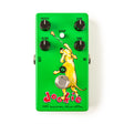 The image shows a bright green guitar effects pedal called the "Dookie 30th Anniversary Deluxe Edition." It features a cartoon-style yellow dog illustration and four knobs labeled OUTPUT, GAIN, BLEND, and TONE. There’s a SCOOP button with an LED above and a footswitch below. Input and output jacks are on the sides. The pedal is designed to emulate classic punk rock tones, inspired by the Green Day album "Dookie."