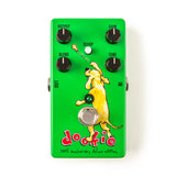 The image shows a bright green guitar effects pedal called the "Dookie 30th Anniversary Deluxe Edition." It features a cartoon-style yellow dog illustration and four knobs labeled OUTPUT, GAIN, BLEND, and TONE. There’s a SCOOP button with an LED above and a footswitch below. Input and output jacks are on the sides. The pedal is designed to emulate classic punk rock tones, inspired by the Green Day album "Dookie."