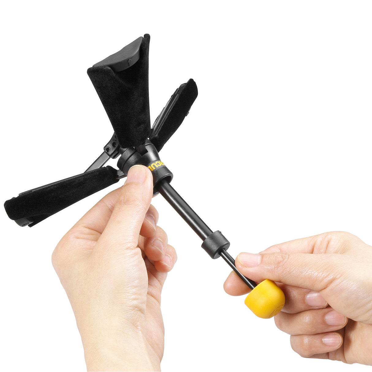 A black clarinet stand being unfolded and adjusted by two human hands