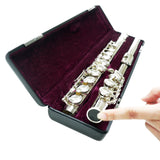 A finger pointing to a silver flute in a case with a folded up stand being stored inside 