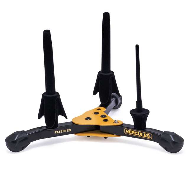 A black and yellow instrument stand with Hercules branding and three pegs to hold flute, clarinet, and piccolo instruments