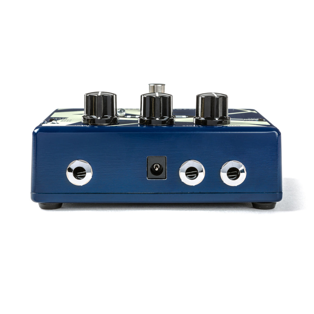 The image shows a blue guitar effects pedal with three black control knobs on top and three chrome input/output jacks on the front, including a central power input. The metal housing suggests a durable, high-quality design. This pedal is used by guitarists and bassists to modify their sound with effects like distortion, delay, or modulation, making it a key accessory for shaping tone in recording and live performances.