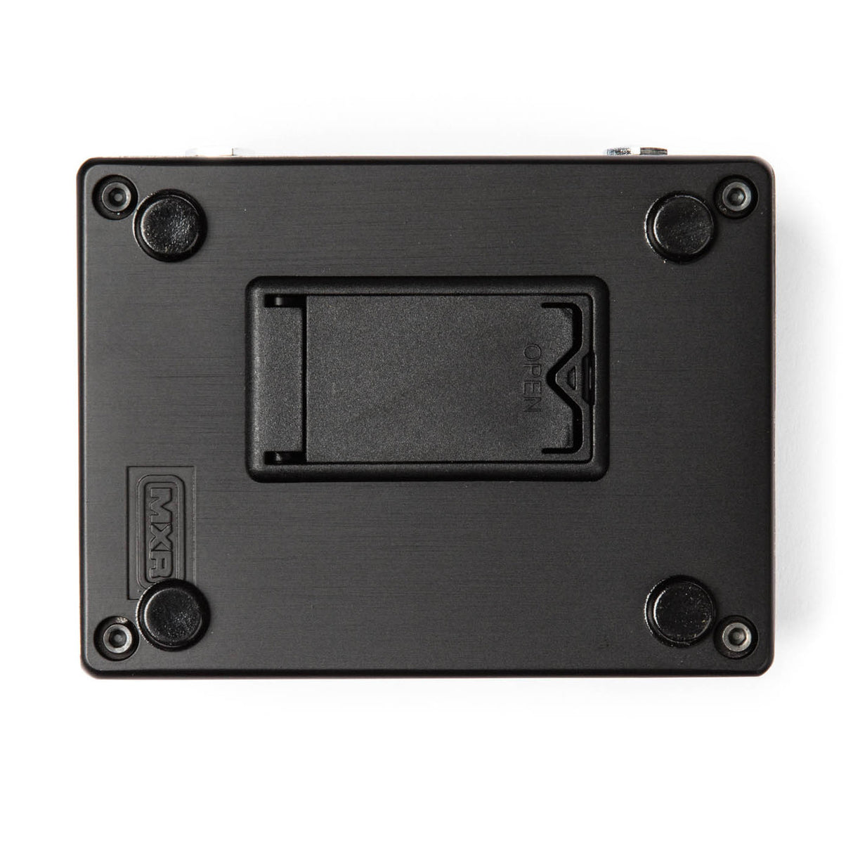 The image shows the underside of a black rectangular musical effects pedal, featuring four rubber feet, a central battery compartment likely for a 9V battery, and four corner screws. The "MXR" brand name is embossed on the bottom left, indicating it is a guitar effects pedal used to modify instrument sound with various audio effects.
