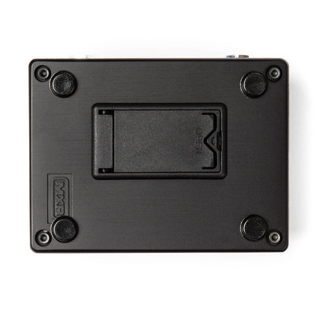 The image shows the underside of a black rectangular musical effects pedal, featuring four rubber feet, a central battery compartment likely for a 9V battery, and four corner screws. The "MXR" brand name is embossed on the bottom left, indicating it is a guitar effects pedal used to modify instrument sound with various audio effects.