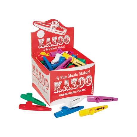 The image shows a retail display box of Hohner kazoos in bright colors like red, blue, yellow, green, purple, and white. The kazoos, made of unbreakable plastic, feature the tagline "A Fun Music Maker!" These beginner-friendly wind instruments create a buzzing sound when hummed and are popular for music education, casual play, and parties. Several kazoos are scattered around the box, highlighting their simple tube-like design.
