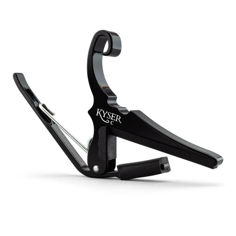 The image shows a Kyser Quick-Change guitar capo with a black finish and spring-loaded, curved arms. The "KYSER" branding is visible on its C-shaped clamp, designed for quick release and easy movement along the fretboard. This popular capo raises pitch by clamping all strings, allowing guitarists to change keys without new fingerings. Kyser capos are known for durability, reliable intonation, and protecting guitar necks.