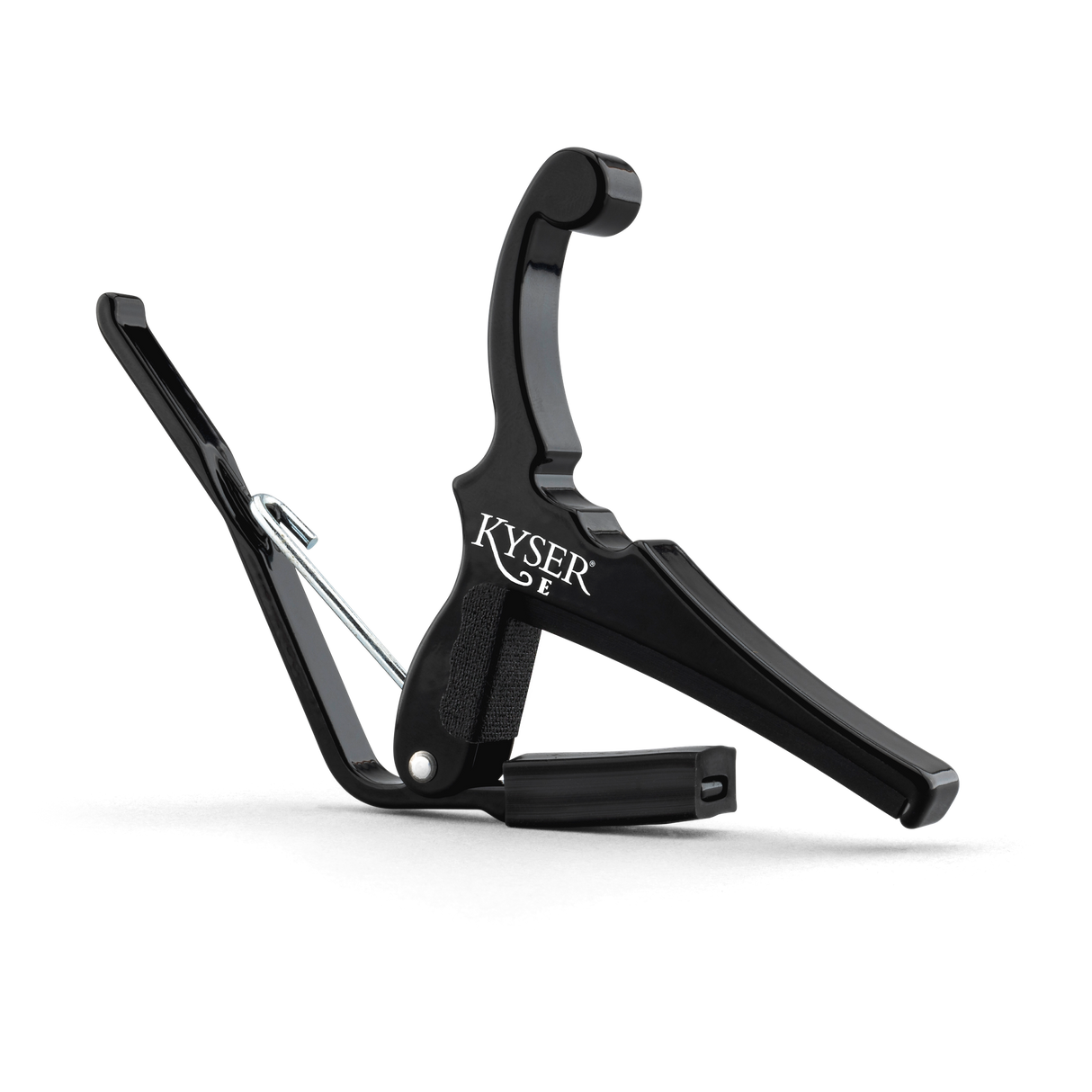 The image shows a black Kyser guitar capo with a spring-loaded mechanism for quick, one-handed use. It features a padded contact surface to protect the guitar neck, an ergonomic handle for easy grip, and the "KYSER" brand name visible. This popular capo lets guitarists quickly change keys without retuning, ideal for acoustic players and singer-songwriters.