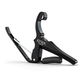 The image shows a KYSER spring-loaded quick-change guitar capo with a sleek black metal frame. It features a curved clamp, padded bar to press strings, a spring mechanism for one-handed use, and an ergonomic grip. Designed for steel-string acoustic or electric guitars, it raises string pitch by clamping across frets, enabling easy key changes while using familiar chords. KYSER is a trusted brand popular with guitarists.