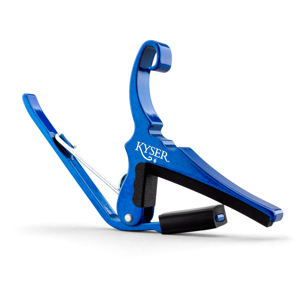 The image shows a bright blue Kyser guitar capo with a spring-loaded, curved clamp design. The "KYSER" name is visible on the metal body. It has black rubber padding to protect the guitar neck and strings while ensuring a secure grip. This quick-change capo is popular for easy one-handed use during performances, offering durability and an attractive anodized finish.