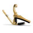 The image shows a Kyser brand guitar capo with a gold/brass metal frame and black padded bar. It features a curved hook shape, spring-loaded mechanism for one-handed use, and black padding to protect the guitar neck. Capos clamp all strings at a fret to raise pitch. Kyser capos are popular for their quick-change design and reliable grip.