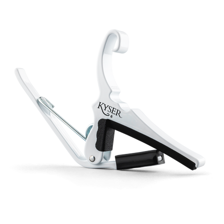 The image shows a white Kyser Quick-Change Capo, a spring-loaded clamp for guitar fretboards. It features a curved design with black rubber padding to protect the neck and frets. The capo allows easy one-handed use, enabling guitarists to change keys quickly while playing. Kyser is a popular brand known for its reliable, fast placement capo models favored by many guitarists.