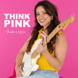 The image shows a classic Fender Stratocaster electric guitar with a white body, maple neck, three single-coil pickups, white pickguard, and chrome hardware. It is featured in the "THINK PINK" campaign, a collaboration between Fender and KYSER, set against a vibrant pink background, likely promoting a special edition or awareness initiative. The Stratocaster is a legendary, versatile guitar used across many music genres.