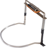 The image shows a harmonica holder, a hands-free metal frame with an orange/wood-colored harmonica mounted on it. It features a curved neck strap with flexible coiled sections and adjustable parts to position the harmonica for playing. This accessory is popular among folk and blues musicians, allowing them to play harmonica while playing other instruments like guitar.