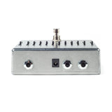 The image shows a guitar multi-effects pedal with a brushed metal housing. The top panel features multiple switches for selecting effects or presets, while the front panel has three chrome knobs for adjusting tone, volume, or intensity, plus a status LED. Designed for guitarists, it allows quick switching between effects like distortion and reverb, making it ideal for live performance and studio use.