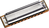 The image shows a Hohner Marine Band harmonica with a chrome top plate featuring "Marine Band" and "SOLITARY" engravings. It has a natural wooden comb, numbered holes 1-10, and the classic rectangular shape of a 10-hole diatonic harmonica. This wind instrument is played by blowing air through the holes to produce notes and is popular in blues, folk, and rock music.