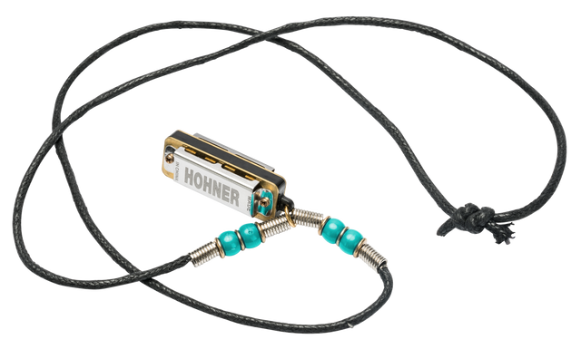 The image shows a small Hohner harmonica creatively repurposed as a wearable necklace. It features a chrome and gold body with the Hohner logo, attached to a black braided cord with turquoise beads and metal wire wraps. The necklace includes an adjustable sliding knot closure. This unique design blends functionality and fashion, allowing musicians to carry and potentially play their instrument as wearable art.