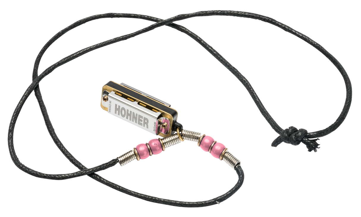 The image shows a Hohner harmonica necklace featuring a small, chrome-plated harmonica with gold reed plates on an adjustable black braided cord. The necklace includes pink beads and metal wire wrappings. Designed for easy, hands-free access, it’s popular among folk, blues, and country musicians. Hohner, a renowned German brand established in 1857, is known for high-quality harmonicas and accordions.