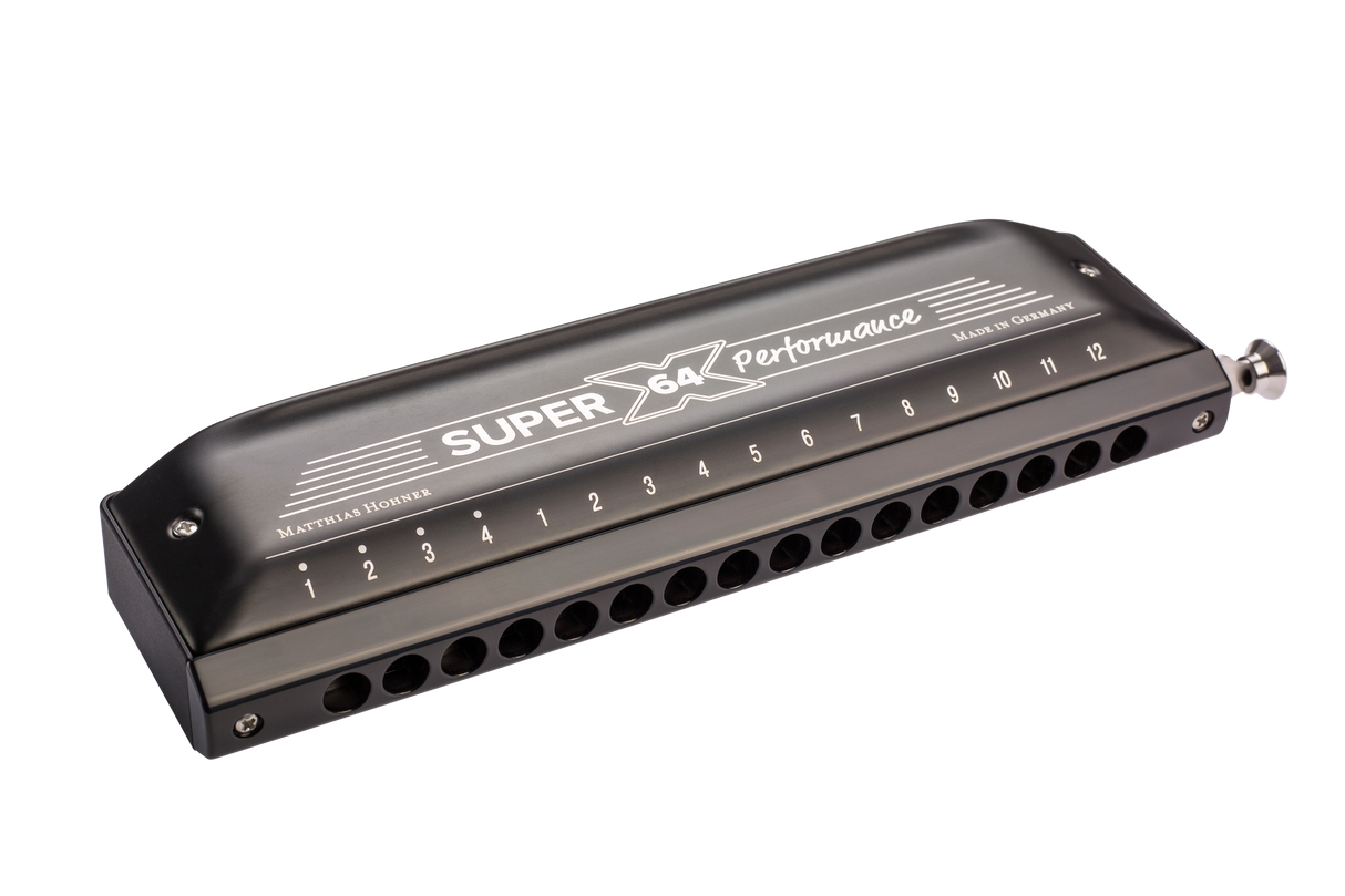 The image shows a Hohner Super 64 Performance chromatic harmonica with a sleek black/dark gray finish. It features a chrome-plated slide button on the right, 12 numbered holes, and "Made in Germany" marking. This professional-quality instrument allows full chromatic play, suitable for various musical styles requiring complex harmonics.