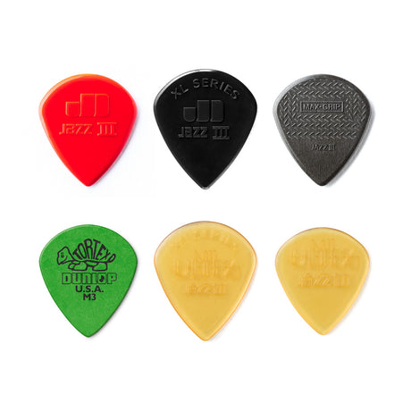 Set of six guitar picks in red, black, green, yellow, and two shades of gray on a white background.